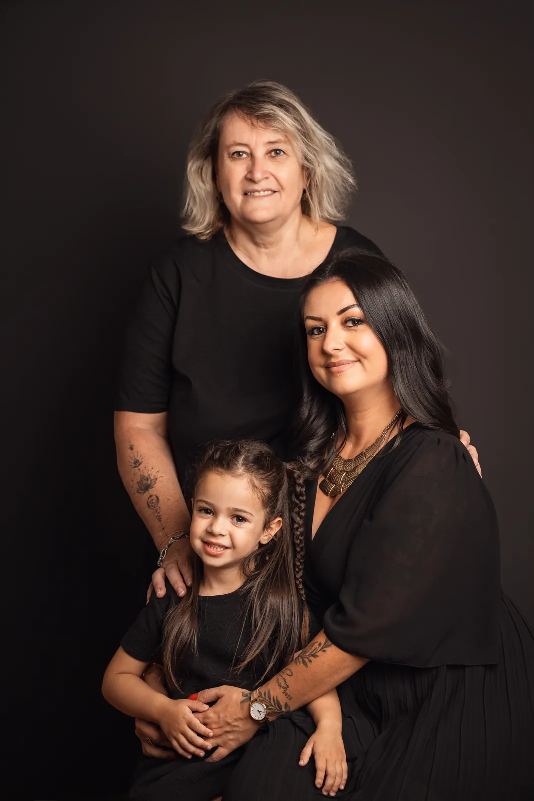 La grand-mère, sa fille Maureen et sa petite-fille Emmie serrées l'une contre l'autre sur fond sombre
