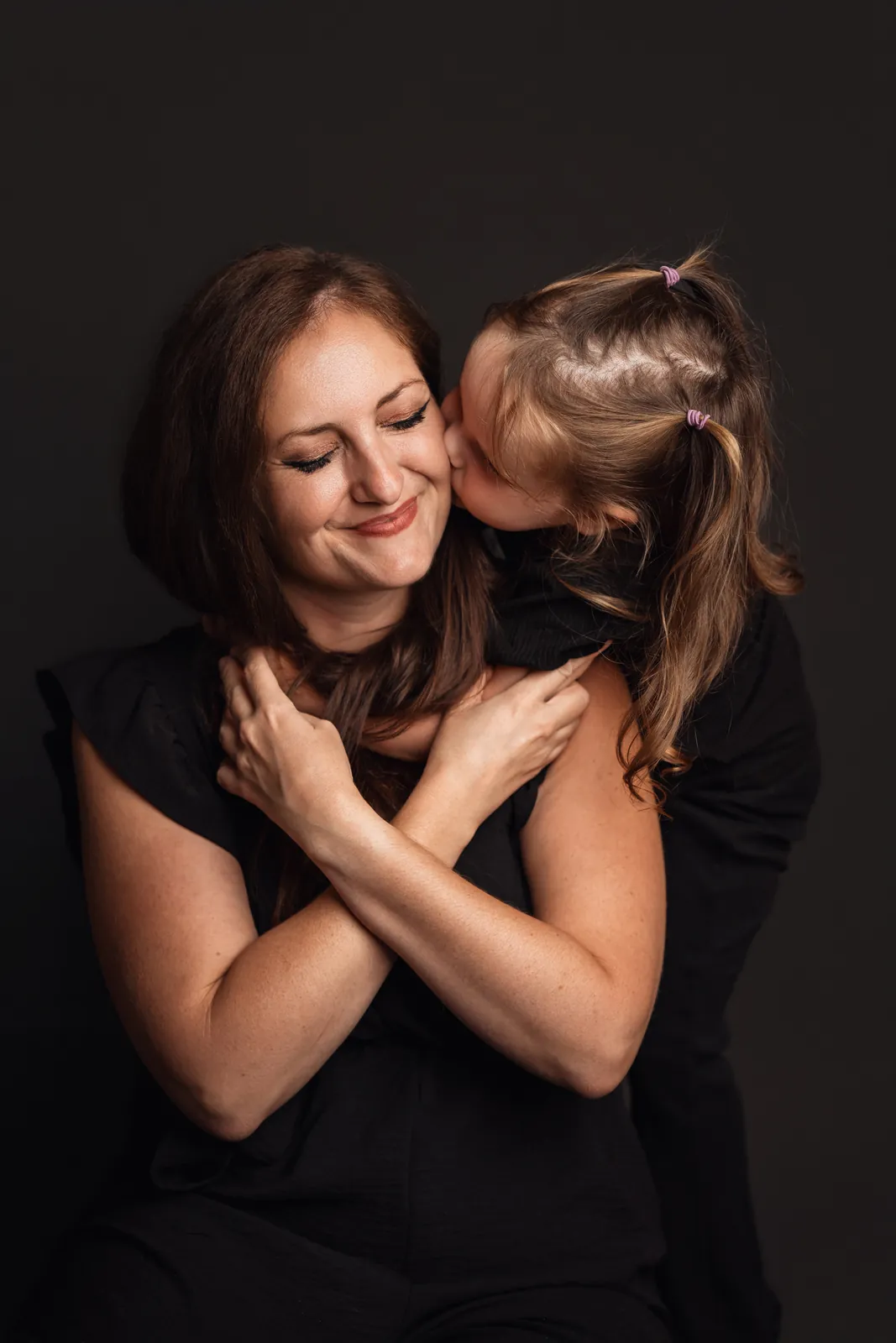 La même photo en couleur : Athena fait un bisou sur la joue de sa maman Megan