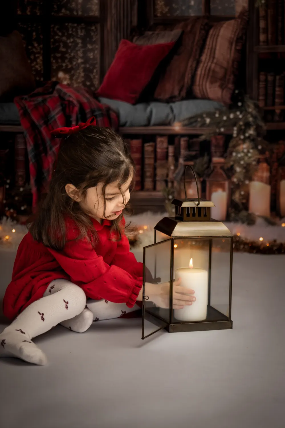Petite fille assise près d’une lanterne et de bougies, photo de Noël enfant à Aix-en-Provence
