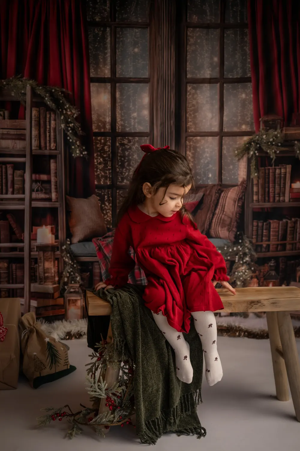 Petite fille assise sur un banc devant une fenêtre, photo de Noël en studio à Aix